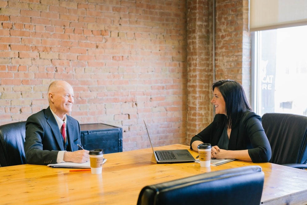 A Man And Woman Talking In A Boardroom