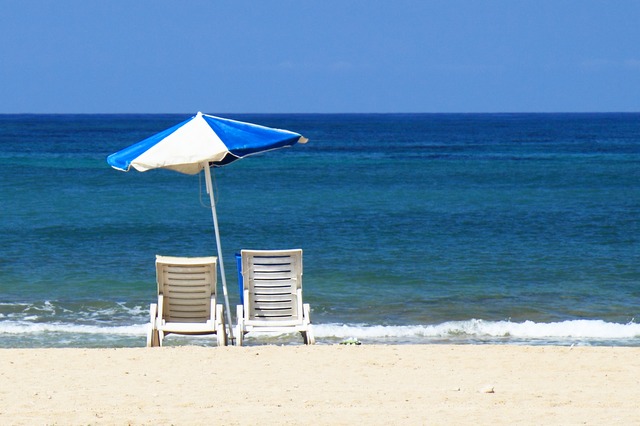 Two Deckchairs Under an Umbrella at the Beach