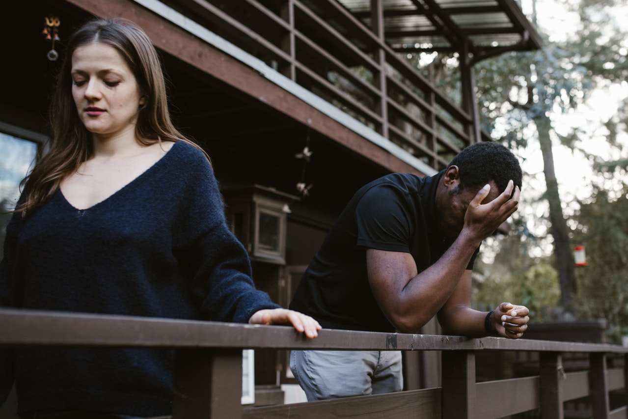 Couple walking away from each other on their front porch.