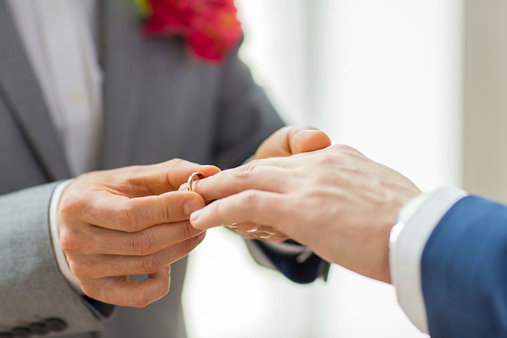 Marriage ceremony where one person is putting the ring on the others hand | Civil Partnership Laws