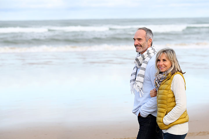 Man And Woman Walking Across The Beach