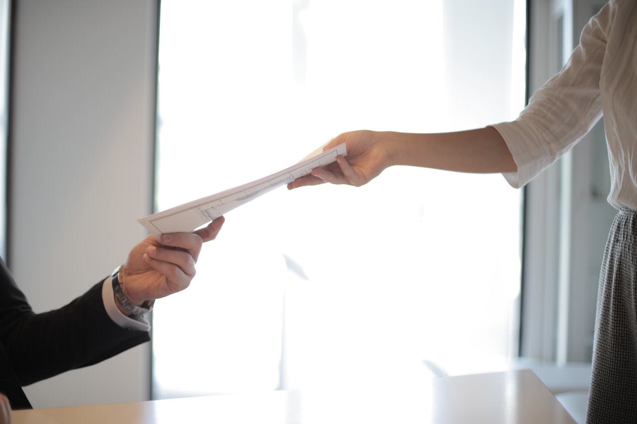 Person handing document over to someone else