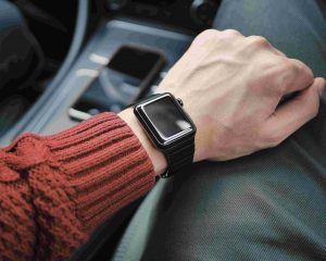 Black smart watch on a driver's wrist.