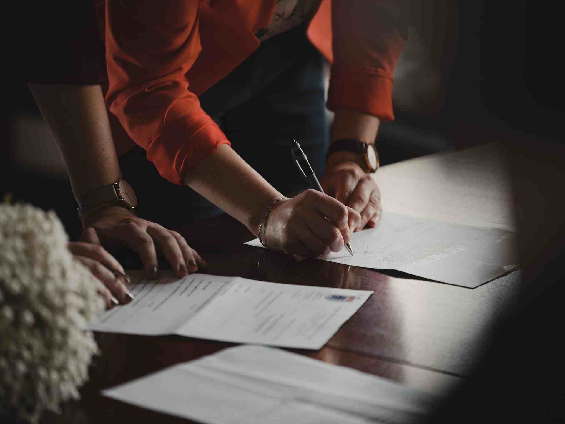 Two people signing documents.