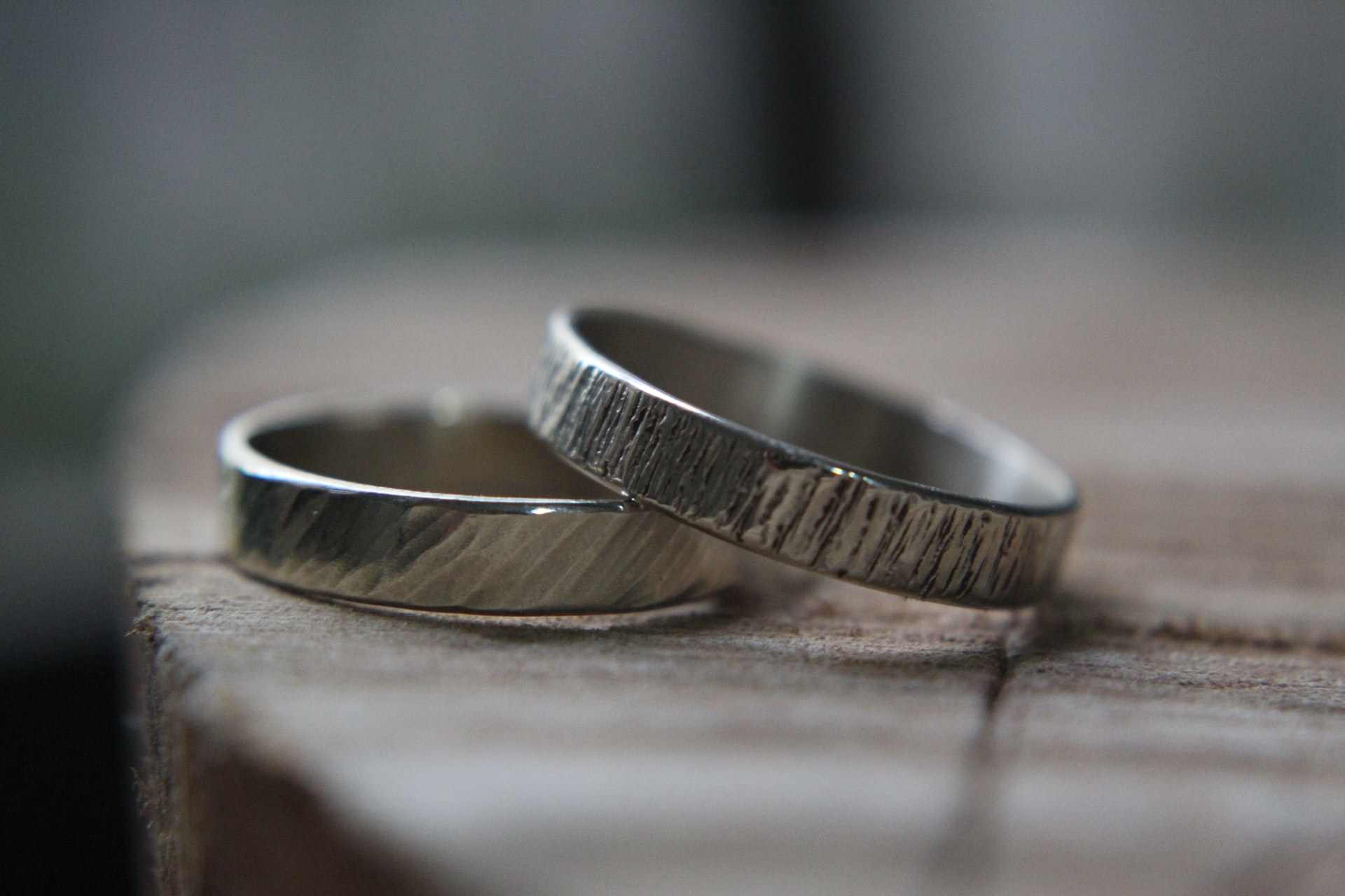 Two silver wedding bands balanced against each other.