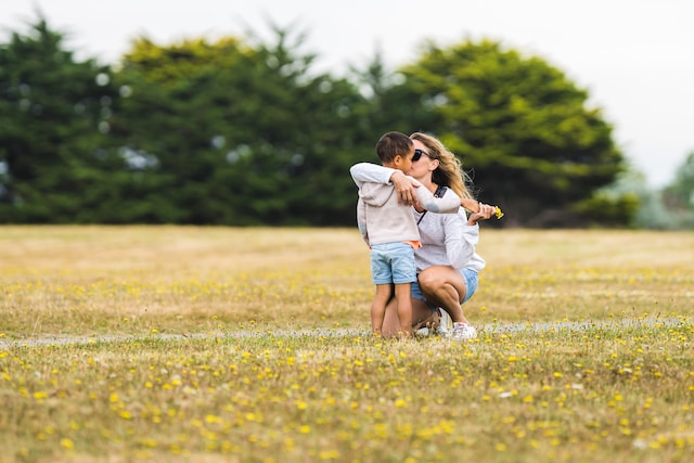 Mother and son hugging in a park.