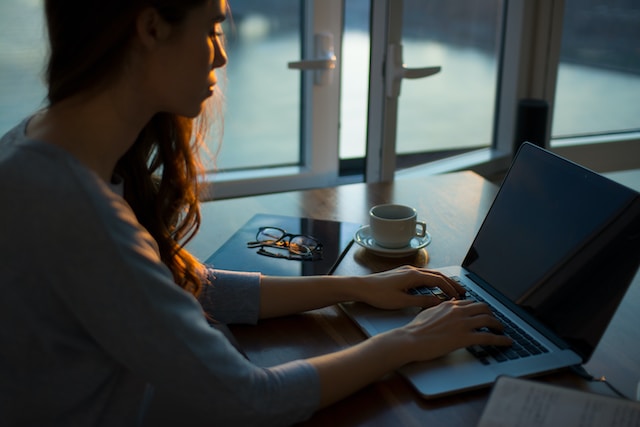 Woman sat at desk on laptop.