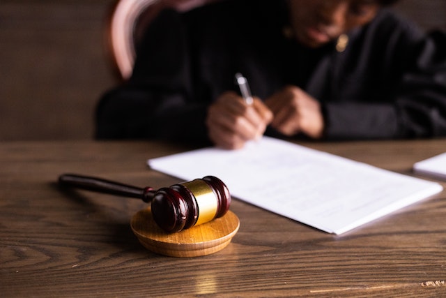 Judge signing a Consent Order. Wooden gavel next to the documents.