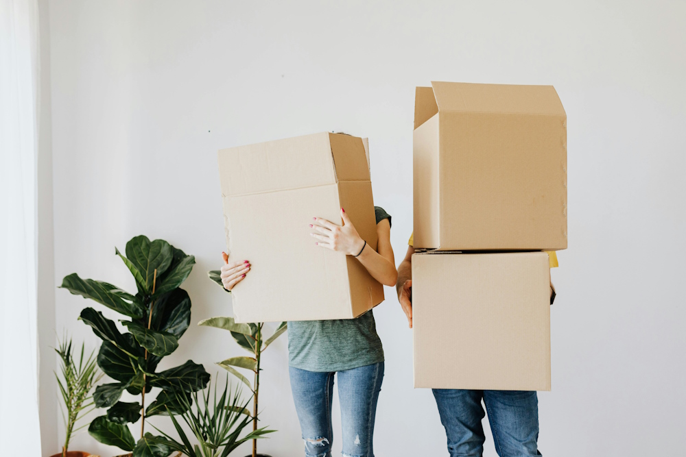 Two people carrying boxes