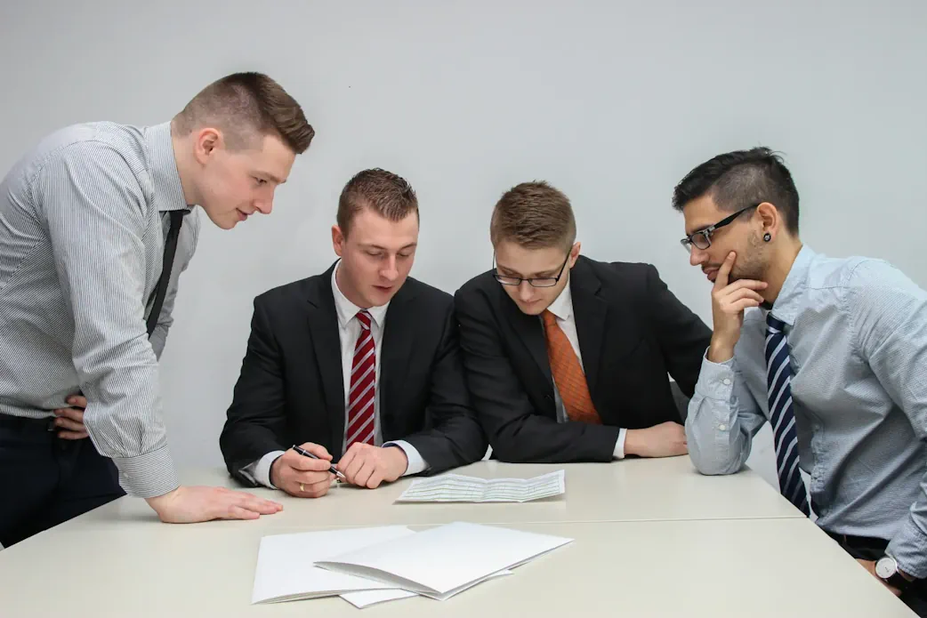 4 Solicitors sat round a table talking about Commercial Property Refinancing.